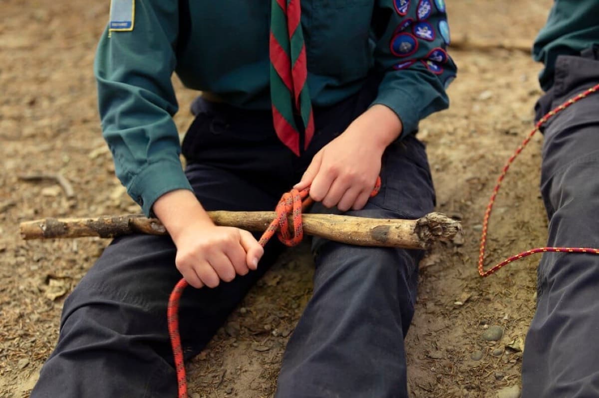 A child practising rope knots outdoors