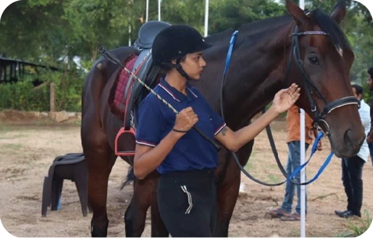 Young rider with her horse at the arena
